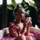 Blissful young woman sitting in bath with eyes closed and drinking hot tea. Portrait of magnificent