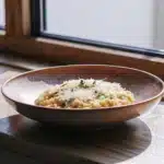 Cremiges Safranrisotto mit Parmesan in einer flachen Keramikschale
